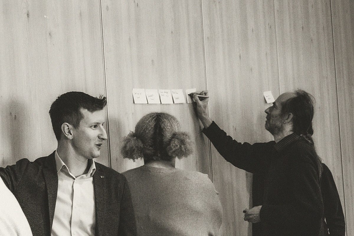 Alfie leading a workshop, sticky notes on the wall behind
